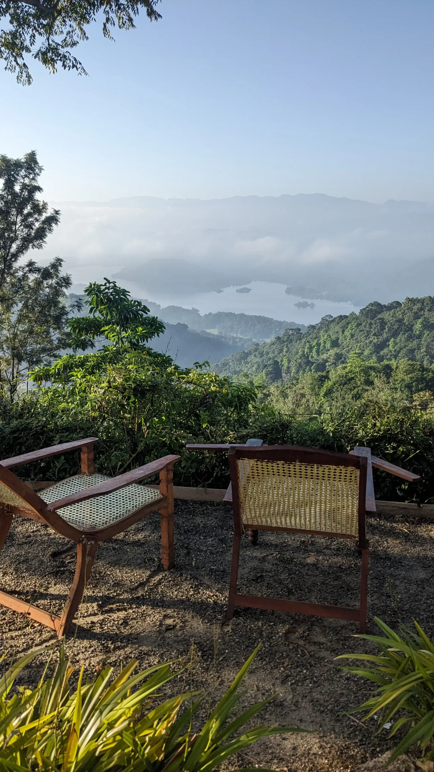 Yoga Retreat, Sri Lanka two rattan chairs at a viewpoint at Welikande Estate are overlooking jungle, lake and mountains of the Knuckles Mountain Range in Sri Lanka